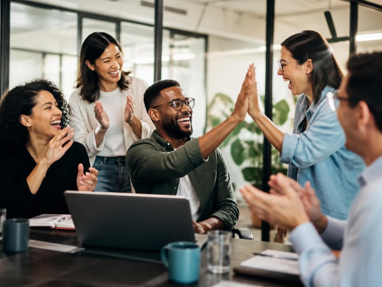 A team celebrating a colleague's win together with a high five